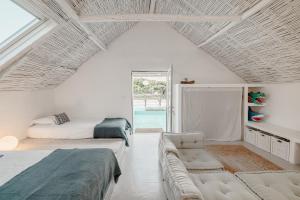 una camera con due letti e un divano in esso di Stunning Seaside Retreat in Azoia, Sesimbra - Casa da Serra a Casais da Azoia Altre 27 foto