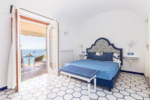 a bedroom with a bed and a balcony with a table at Villa Nannina in Positano