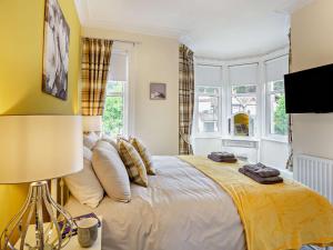 a bedroom with a large bed with yellow walls at 4 Bed in Llandudno 95235 in Llandudno