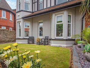a house with yellow flowers in the yard at 4 Bed in Llandudno 95235 in Llandudno