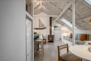 un soggiorno e una sala da pranzo con una barca a vela sul soffitto di Stunning Seaside Retreat in Azoia, Sesimbra - Casa da Serra a Casais da Azoia