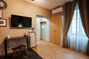 a living room with a television and a table with a chair at Arci Loft in Tivoli