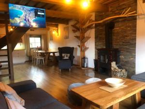 a living room with a table and a fireplace at Chalupa Grúnik in Zázrivá