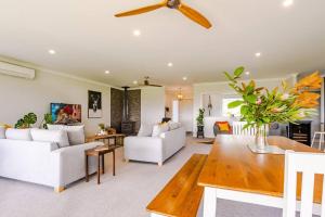 a living room with white furniture and a ceiling fan at Fraters Escape - Martinborough in Martinborough 
