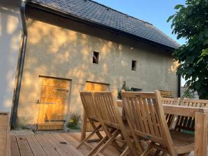 two wooden chairs and a wooden table on a deck at chalupa Dřemčice -České středohoří in Litoměřice