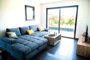 a living room with a blue couch and a table at Villa laudun in Laudun