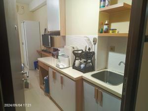 a small kitchen with a sink and a refrigerator at Cozy Furnished Studio Apartemen Transpark Cibubur by Royal Home Indonesia in Kalimanggis +9 photos