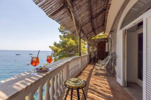a balcony with a table and two glasses of wine at Villa Nannina in Positano