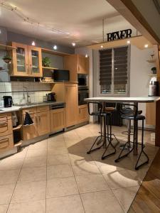 a large kitchen with a table and stools in it at Grand appartement centre ville in Le Creusot