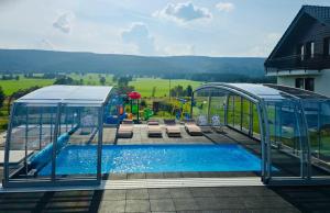 a pool in a gazebo next to a playground at Jagodowy Ski&Spa pensjonat z widokiem na góry,podgrzewany basen zewnętrzny latem,bilard,świetne Wi-Fi,Restauracja,balia,sauna na miejscu in Lasowka