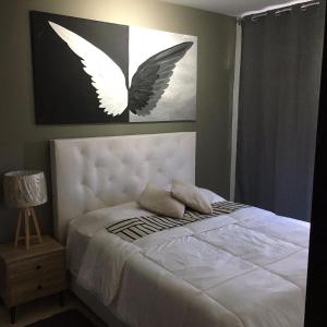 una camera da letto con un letto bianco e un dipinto a farfalla sul muro di Lujoso apartamento en Valencia 4 a Valencia Altre 16 foto