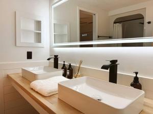 a bathroom with a white sink and a mirror at Woodland Reserve - Mini Golf, Home-Gym, and More! Only 10 Minutes from Downtown in Casa Cola +77 photos