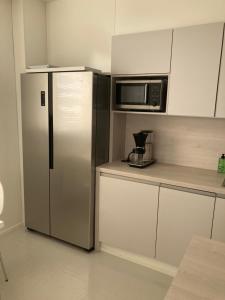 a kitchen with a stainless steel refrigerator and microwave at Rovaniemi center apartment in Rovaniemi