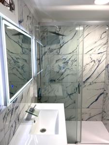 a bathroom with a sink and a glass shower at Río Canario 102 in Mogán +4 photos