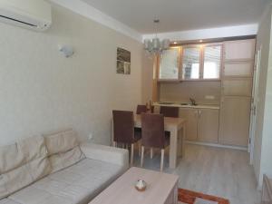 a living room with a couch and a table and a kitchen at Harmony Suites 11 Grand Resort in Sunny Beach