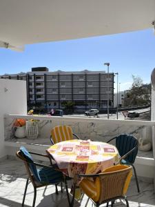 a table and chairs on a balcony with a building at Río Canario 102 in Mogán