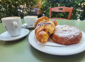 a table with two plates of pastries and cups of coffee at In Parva Domus - Cute and Central Mini Suite Apt in Bitonto