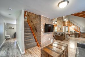 sala de estar con escalera y pared de ladrillo en Fire Pit and Grill Spacious Forest Lakes Chalet, en Forest Lakes Estates