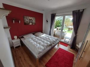 a bedroom with a bed and a red wall at Feriendomizil-Stegemann in Trassenheide