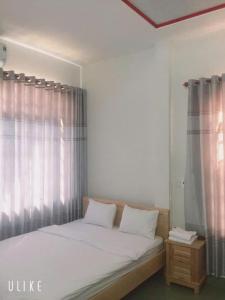 a bedroom with a large bed with a window at Nhà Nghỉ Thanh Thủy in Xã Phước Lễ +7 photos