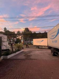 two trucks parked in a parking lot at sunset at Nhà Nghỉ Thanh Thủy in Xã Phước Lễ