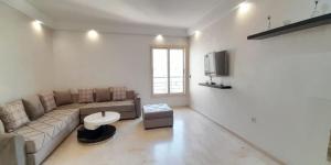 a living room with a couch and a tv at EuroStar Appartement in Casablanca