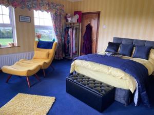 a bedroom with a large bed and a chair at Arney Lodge Farm in Newtownstewart