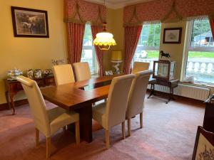 a dining room with a wooden table and chairs at Arney Lodge Farm in Newtownstewart
