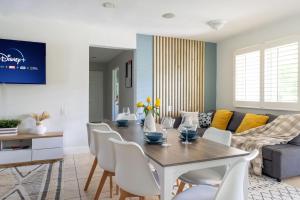 フォート・ローダーデールにあるHeated Saltwater Pool 6min to Beach Tropical Oasisのテーブルと椅子のあるダイニングルームとリビングルーム