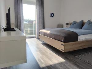 um quarto com uma cama e uma escrivaninha com uma televisão em Apartment Fasching em Deutsch Goritz