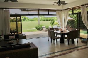 a living room with a table and a couch at VillaFV GuavaBerry-JuanDolio-4BR-6Bds-12Pax-AC-WiFi-BBQ-GolfView in Paraíso