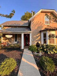 a brick house with a sidewalk in front of it at Historic Home in the Heart of Elora in Elora