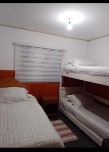 a bedroom with two bunk beds and a window at Cabaña muy cómoda cerca de Saltos del Laja in Cabrero