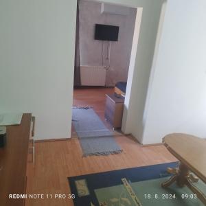 ein leeres Wohnzimmer mit einem Tisch und einem Fernseher in der Unterkunft Salvatori in Garić