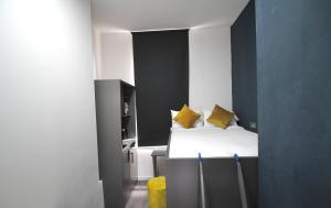 a small room with a bed with yellow pillows at NE1 City Studios & Apartments in Newcastle upon Tyne