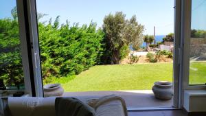 a sliding glass door with a view of a yard at Villa with Aegean views in Akhladherí