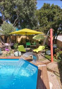 a swimming pool with an umbrella and a water slide at Studio chez ISA in Ventiseri +15 photos