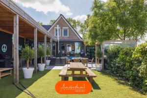 una casa con tavolo da picnic in cortile di Amsterdam Group Stay - Jacuzzi, Sauna & Cinema a Zwanenburg Altre 37 foto