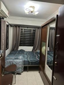 a small bedroom with a bed and a window at SS Homestay in Johor Bahru