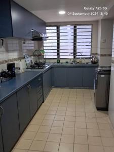 a kitchen with blue cabinets and a tiled floor at SS Homestay in Johor Bahru
