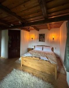 a bedroom with a wooden bed in a room at Emma's Lake Houses in Bîrsana