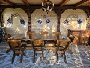 a dining room with a wooden table and chairs at Emma's Lake Houses in Bîrsana