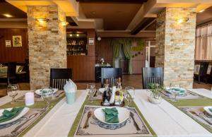 ein Esszimmer mit einem Tisch, Tellern und Gläsern in der Unterkunft Hotel Kibor in Gŭlŭbovo
