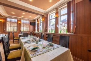 ein Esszimmer mit Tischen, Stühlen und Fenstern in der Unterkunft Hotel Kibor in Gŭlŭbovo