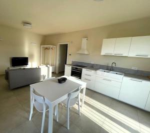 a kitchen with a white table and white cabinets at LOCANDA del BRICCO pt in Cisterna dʼAsti