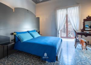 una camera da letto con un letto blu e una finestra di Le Dimore dei Principi a Catania
