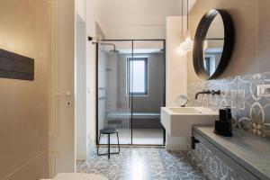 un bagno con doccia, lavandino e specchio di Le Dimore dei Principi a Catania