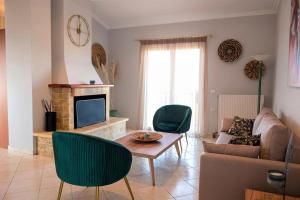 a living room with a couch a table and a tv at Elenas Villas in Kyllini