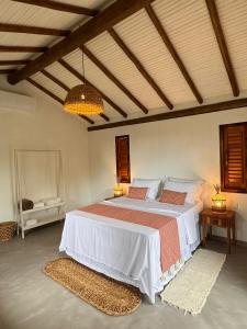 una camera da letto con un grande letto con due tappeti di Pousada Porto Caraíva a Caraíva