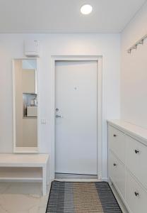 a white room with a white door and a mirror at Pramonės Apartment #5 by PoloApartments in Kaunas +16 photos